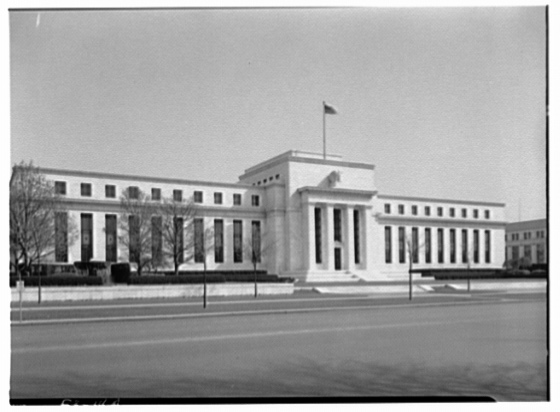 Black-and-white photograph of the Federal Reserve Building exterior, showing the full front facade against open sky.