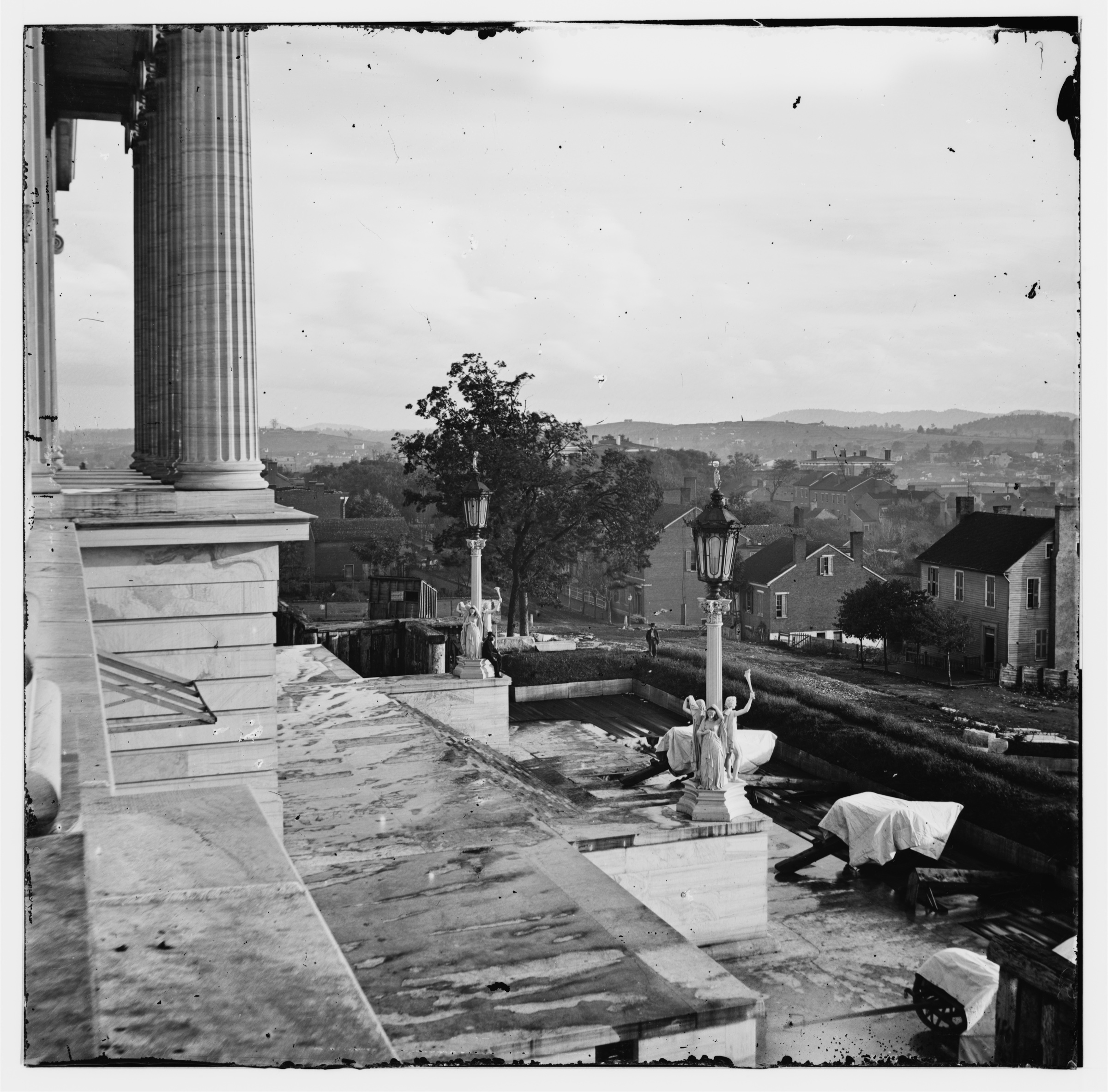 Steps of the Tennessee State Capitol in Nashville, 1864, with covered guns under tarps and the city beyond, photographed by George N. Barnard.